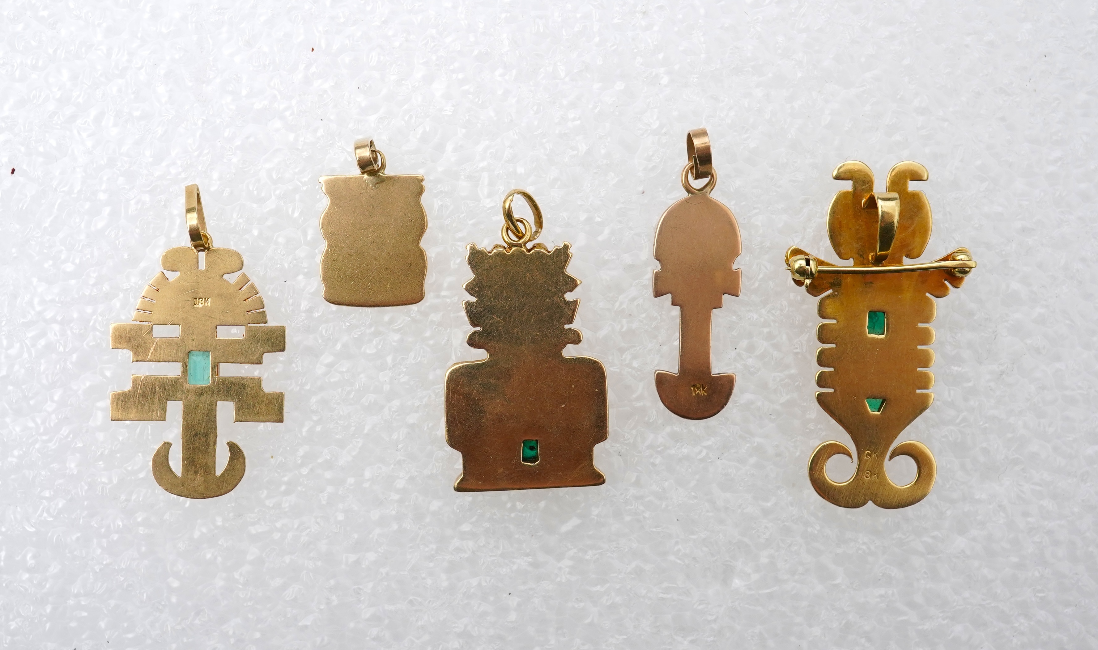 A collection of five gold pendants